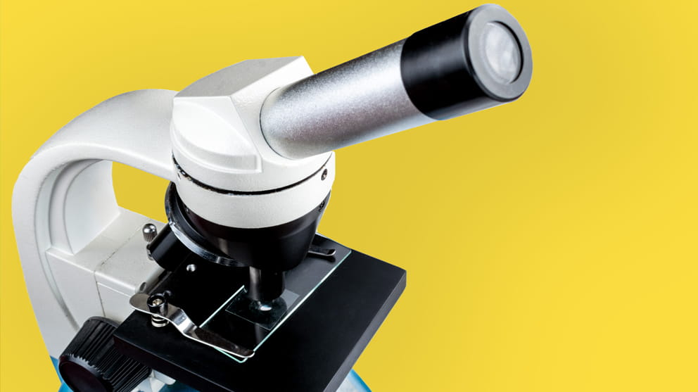 White microscope on yellow background
