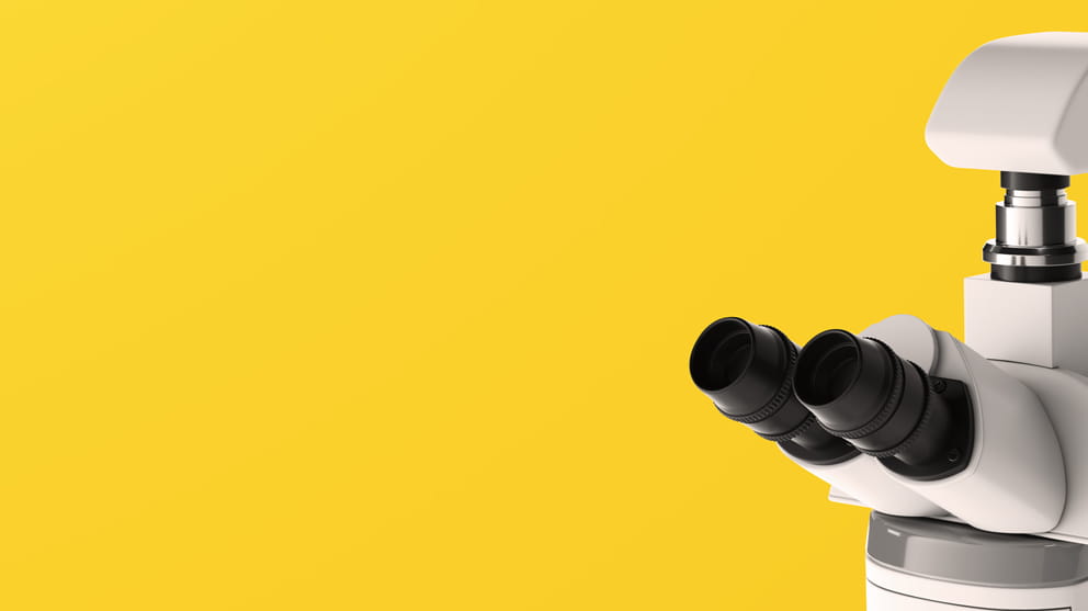 White microscope on yellow background