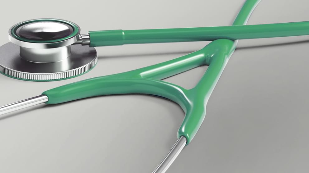 Green stethoscope on grey background