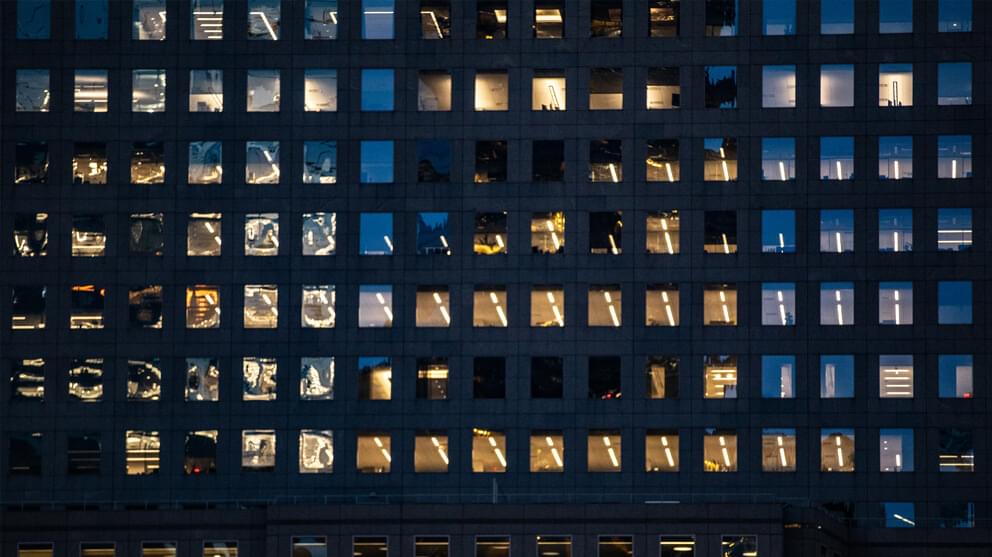 Close up of office windows at night with some office lights on