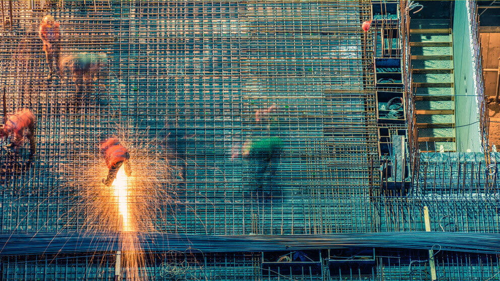 Construction site at night with workers welding