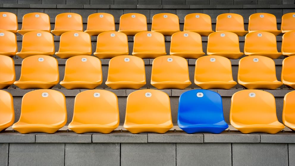 Empty blue seat in the middle of yellow seats